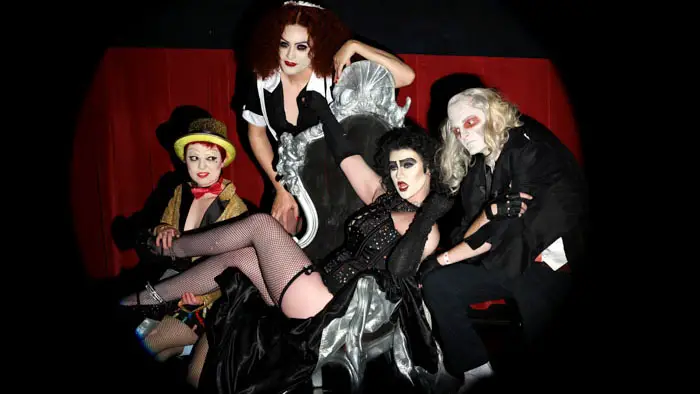 Four costumed participants pose theatrically in character from The Rocky Horror Picture Show at a TCM Classic Film Festival screening event.