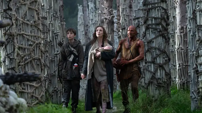 Spike, Isla, and Kelson walk through forest of skeletal pillars in 28 Years Later