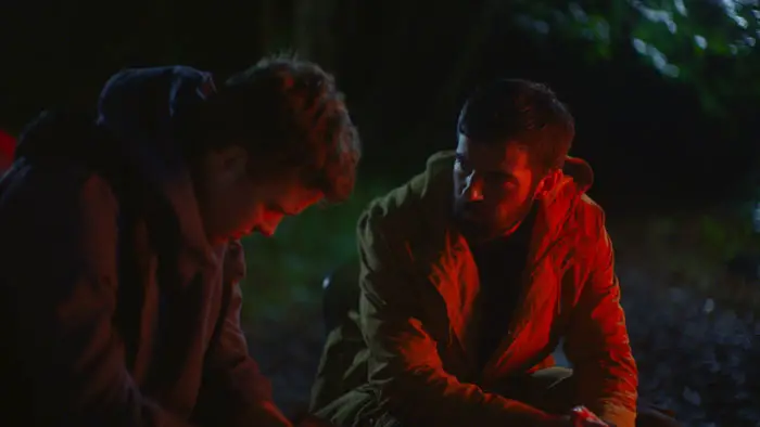 Danny and Will sit by a campfire in a tense, emotional moment from Amongst the Wolves.