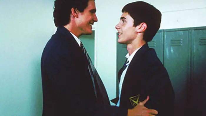 Brad Gorton and Ben Silverstone share a tender moment as John and Steven in Get Real (1998), standing together in their school uniforms by the lockers.