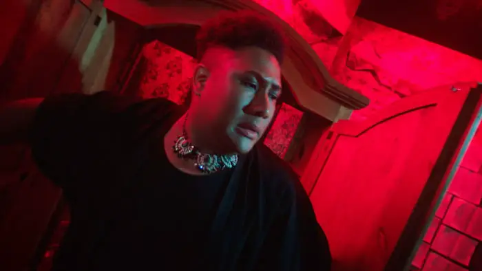 Roger Mason as Tafeta in Lavender Men under red lighting