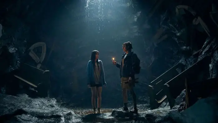 Dave Franco and Alison Brie stand in a dark, flooded cave in Together (2025)