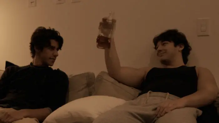 Two young men talking on couch in Toxoplasma