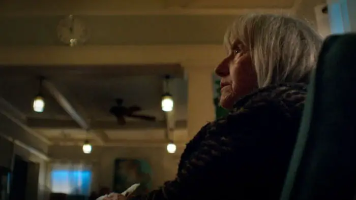 Gladys sits in the shadows, preparing for a dark ritual in Whitch.