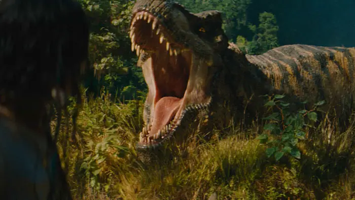 A roaring Spinosaurus charges through the jungle in Jurassic World: Rebirth.