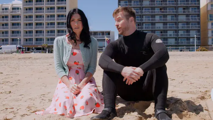 Natalie Veater and Chris Maher sitting on the beach in Boardwalk Winter