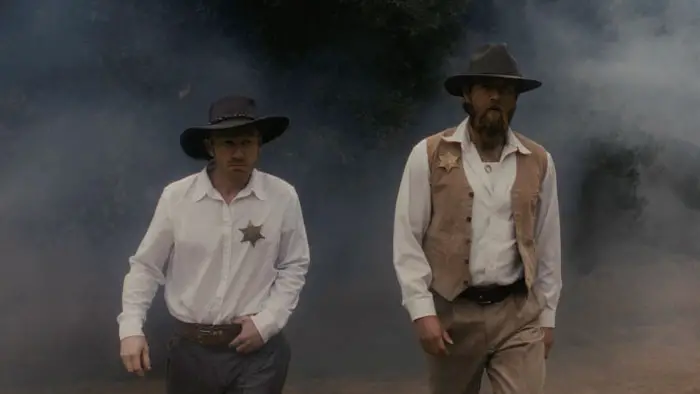 Two lawmen walk through a smoky forest in American Clay.