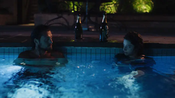 Michael Vlamis and Odessa A’zion sit in a swimming pool in Pools.