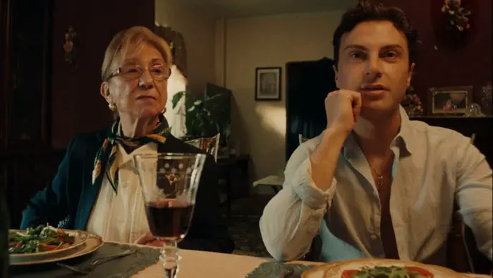 Dinner table scene from Sunday Sauce with elderly woman and young manTitle: Dinner Scene in Sunday Sauce