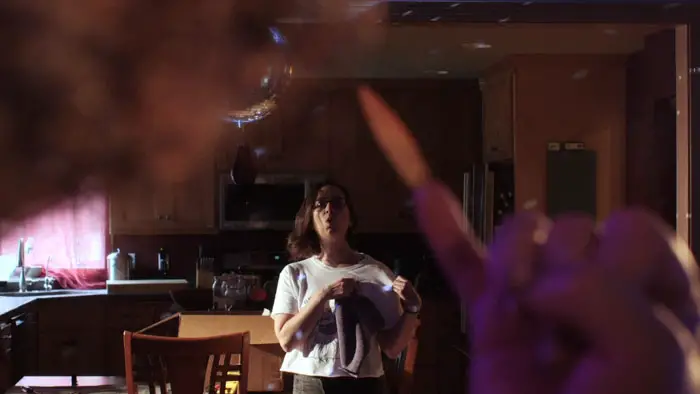 Kate Houle in a tense kitchen scene from the horror-comedy The Xxtra Deadd