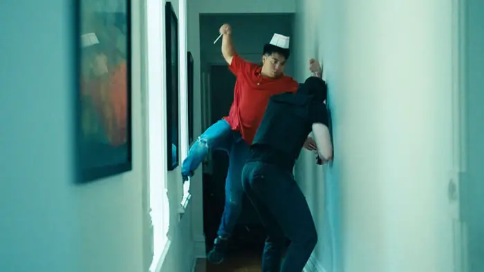 Fight scene in Beef Fried Rice with a man in a red shirt attacking an opponent in a hallway