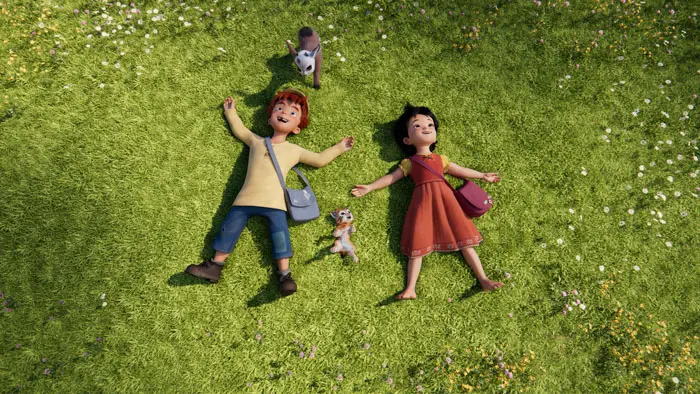 Heidi and a friend lying on the grass with animals in the Swiss Alps