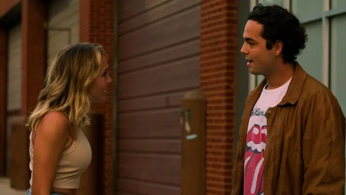 Ray and Cecilia argue outside near a brick building in Third Wheel.