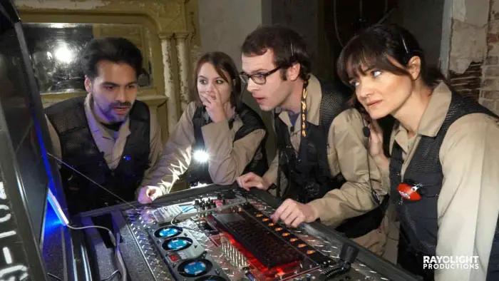 The paranormal investigation team studies a high-tech control panel inside the haunted Hennesy House.