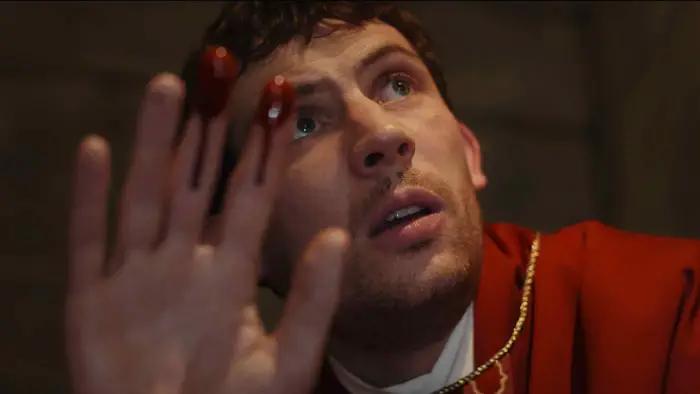 Father Jud Duplenticy looks at his bloody hand in Wake Up Dead Man: A Knives Out Mystery.