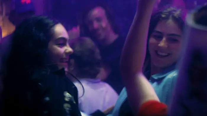 Kate and Lily dancing in a purple-lit club scene from Wrecking Party