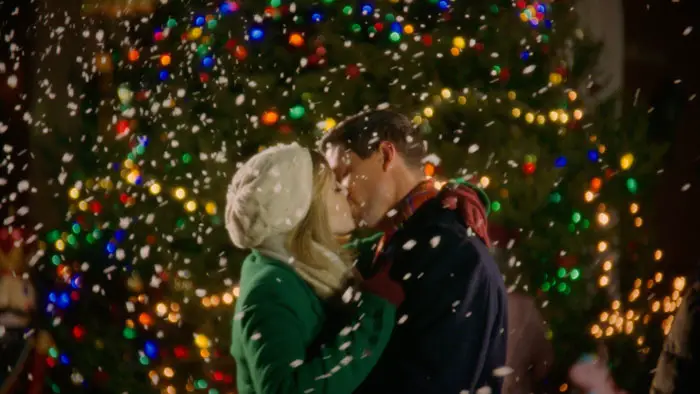 Tom and Annie share a kiss in front of the Christmas tree in A Chrismystery