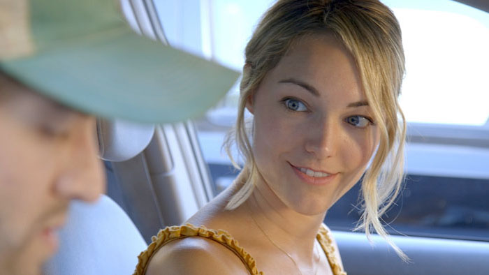 Woman smiling at a man inside a parked car in Falling Sons (2025)