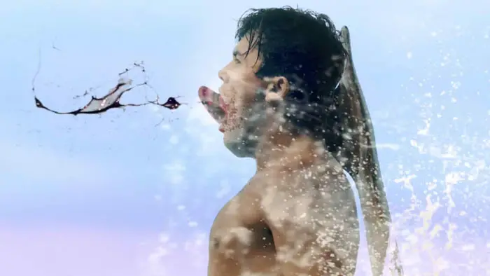 Surfer and figure in robe ride a massive wave in Plankenstein: A Killer Surf Movie