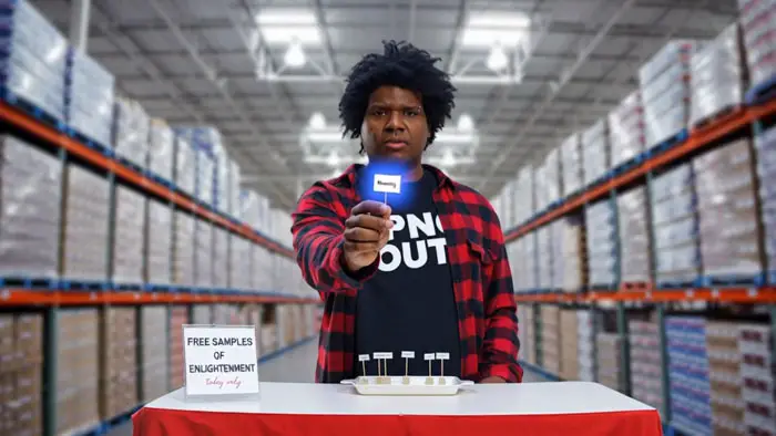 Todd Montessi offering a glowing sample labeled “Memory” at a table inside a warehouse in PN and Friends. 