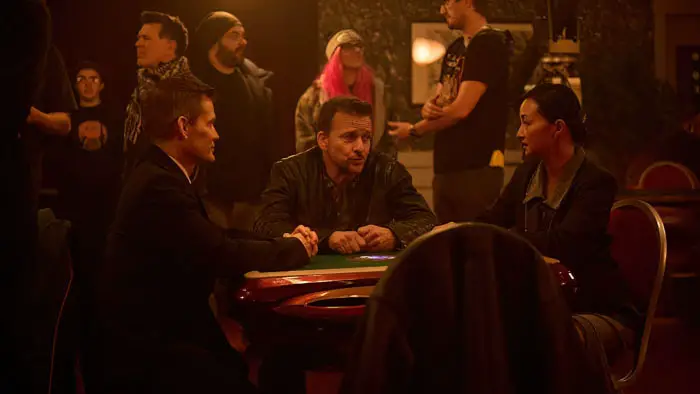 Casper Van Dien, Sean Patrick Flanery, and Theresa Lee sitting at a poker table in Ruthless Bastards.