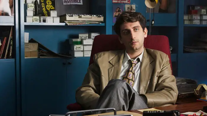 Pietro Castellitto as Riccardo Schicchi sitting in his office in Sex Diva (Diva Futura) 