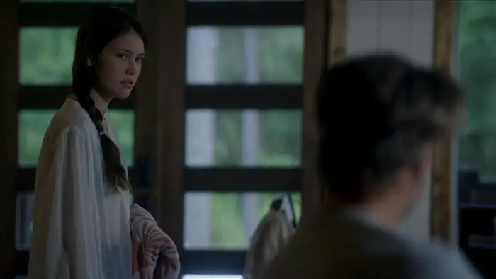 Kaylee stands inside the cabin looking toward her parents in The Veil. 