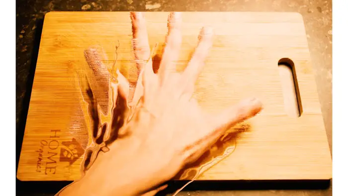 Konrad’s distorted hand appears to melt into a wooden cutting board during his psychedelic trip in Trip Report by a Psychonaut.