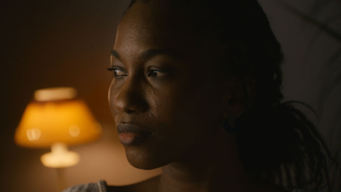 Close-up of a woman looking into the distance in Where There Is Love, There Is No Darkness