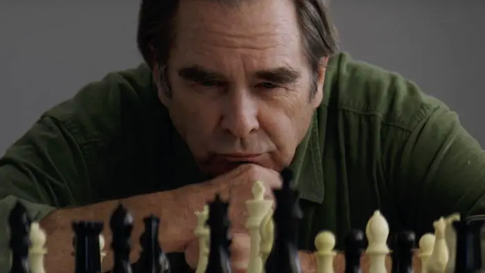 A woman sits alone in quiet reflection in a scene from the film Blue Eyed Girl (2025)