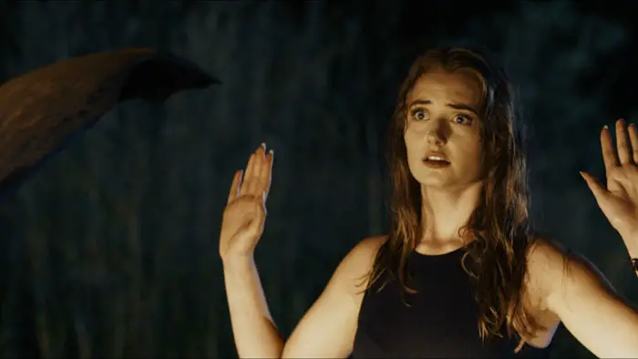 Aimee Botes as Amelia raising her hands during a tense nighttime ambush in Lost Horizon.