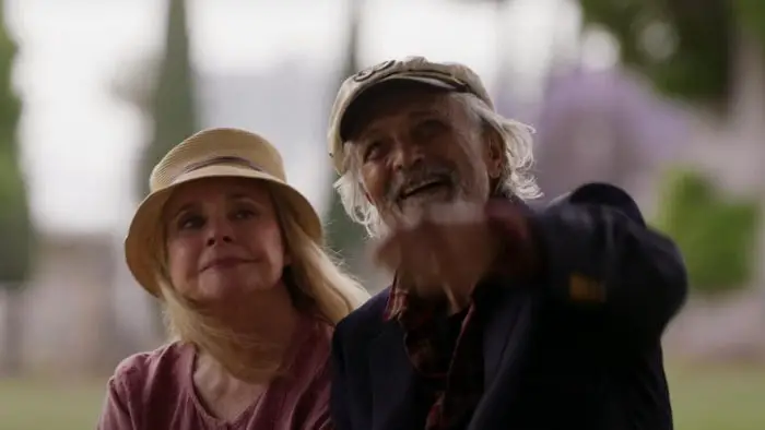 Robert and Claire sit together on a park bench in Mr. Wonderful