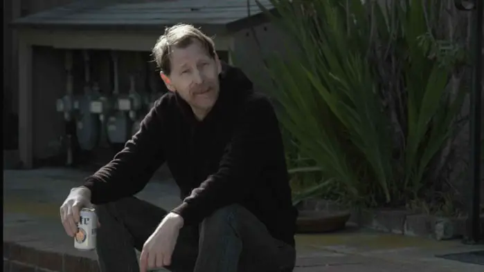 Reid Schmidt as Owen Block sits outside the off-campus rental house in My First Year Off Campus (2025). 