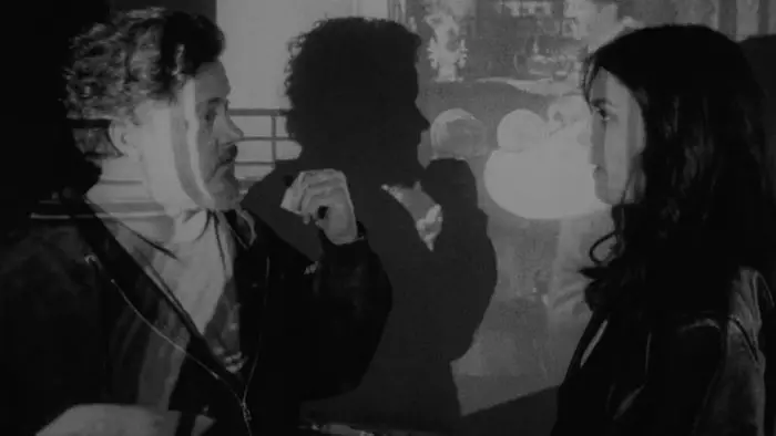 Caleb and Dylan stand together in a projected black-and-white image in a scene from Objects of Affection.