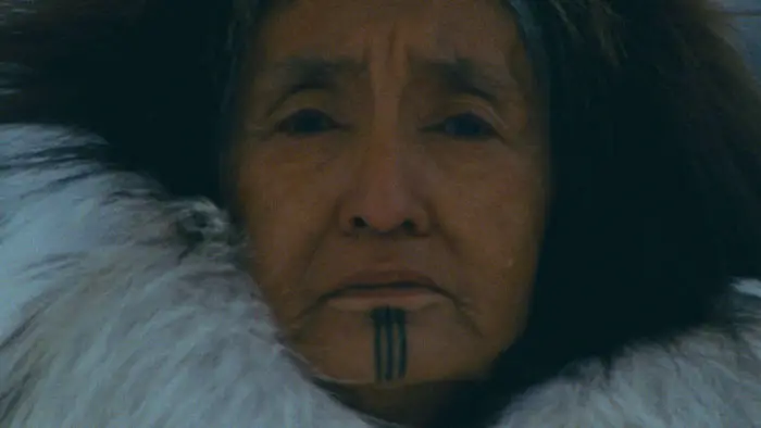 Close-up of Sa’, played by Margaret Henry John, wearing traditional fur clothing in the Alaskan wilderness from Shaaghan Neekwaii: Two Old Women. 