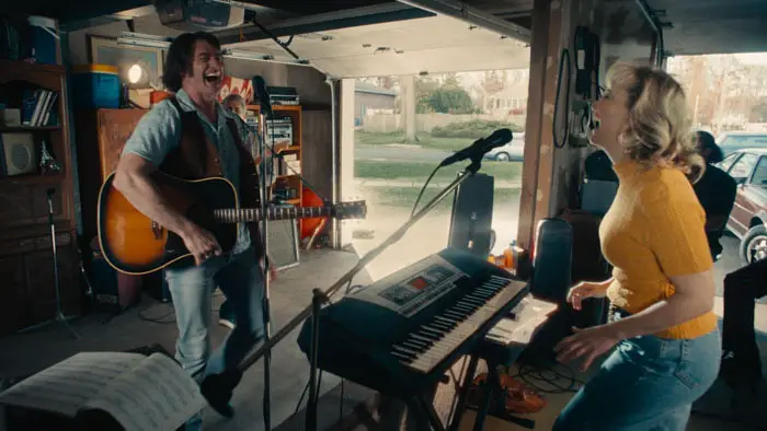 Hugh Jackman and Kate Hudson rehearse music in a garage in Song Sung Blue (2025).