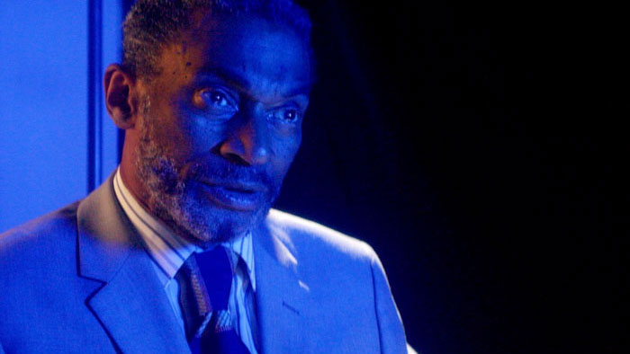 LeJon Stewart as Todd under blue lighting in The Job (2025). 
