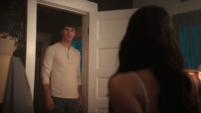 Ryan stands in the bedroom doorway looking shocked in a scene from The Keeping.