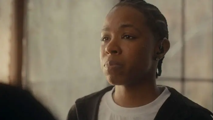 Andrea “Drea” Stoney stands quietly during the family repass in Them That’s Not (2025).