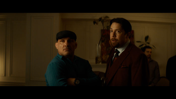 Shirtless dancer “Legend” confronts a man in a hard hat in Legend Has It.