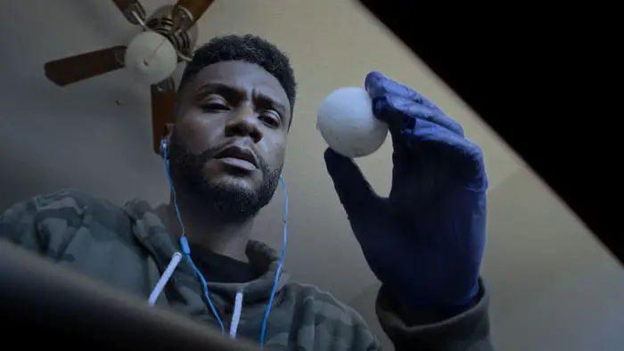 Kevin (Mychal Thompson) examines a mysterious egg in Molt (2026). 