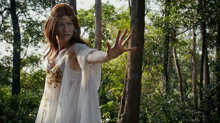 High Elf woman in white gown raises her hand in the forest in The Warriors Tale: Circle of Hatred (2026).