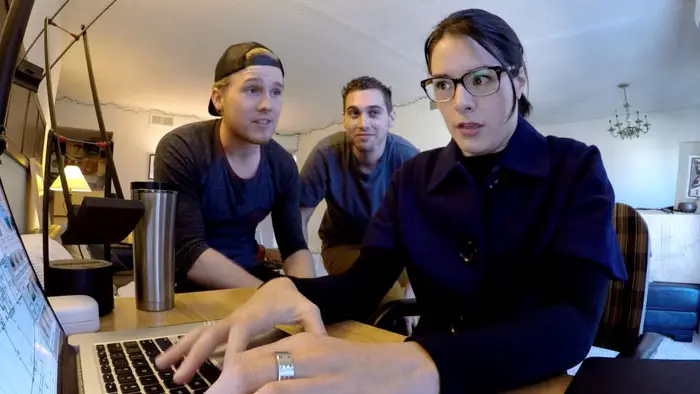 Tucker J. James typing on a laptop while two friends watch in Namas Dei The Tucker J. James Story