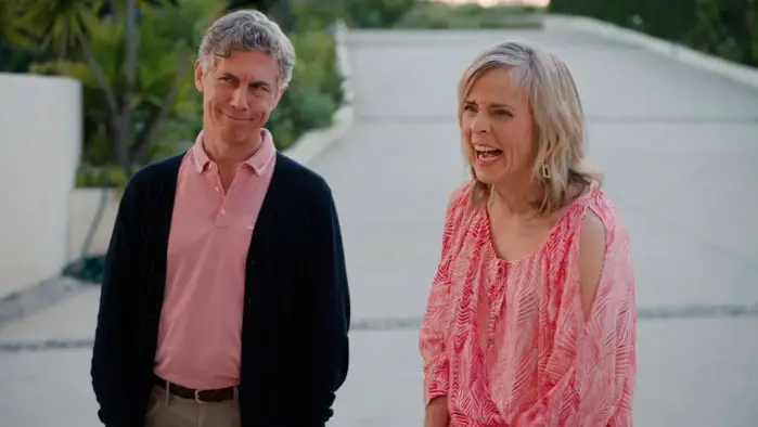 Two characters stand outside a house in Micro Budget during a tense production moment.