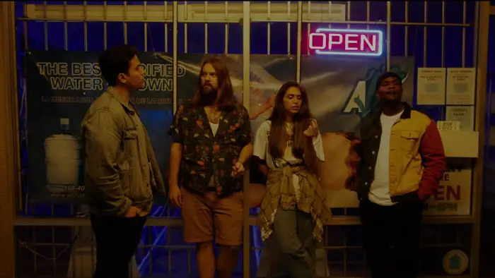 A group of friends stands outside a video store in The Director’s Cut.
